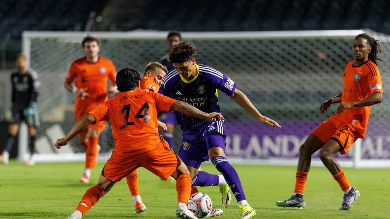 Enriquez y jugador de Orlando City en acción Enriquez y jugador de Orlando City en acción