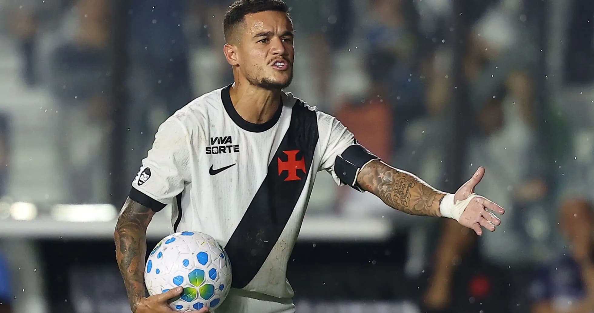 Jugador de fútbol sosteniendo un balón y señalando Jugador de fútbol sosteniendo un balón y señalando