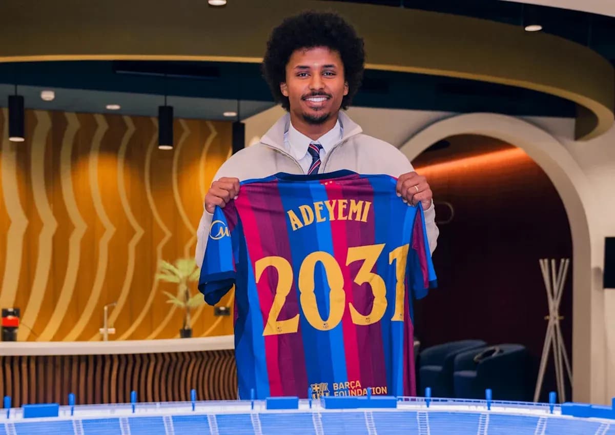Jugador sosteniendo camiseta del FC Barcelona con nombre Jugador sosteniendo camiseta del FC Barcelona con nombre