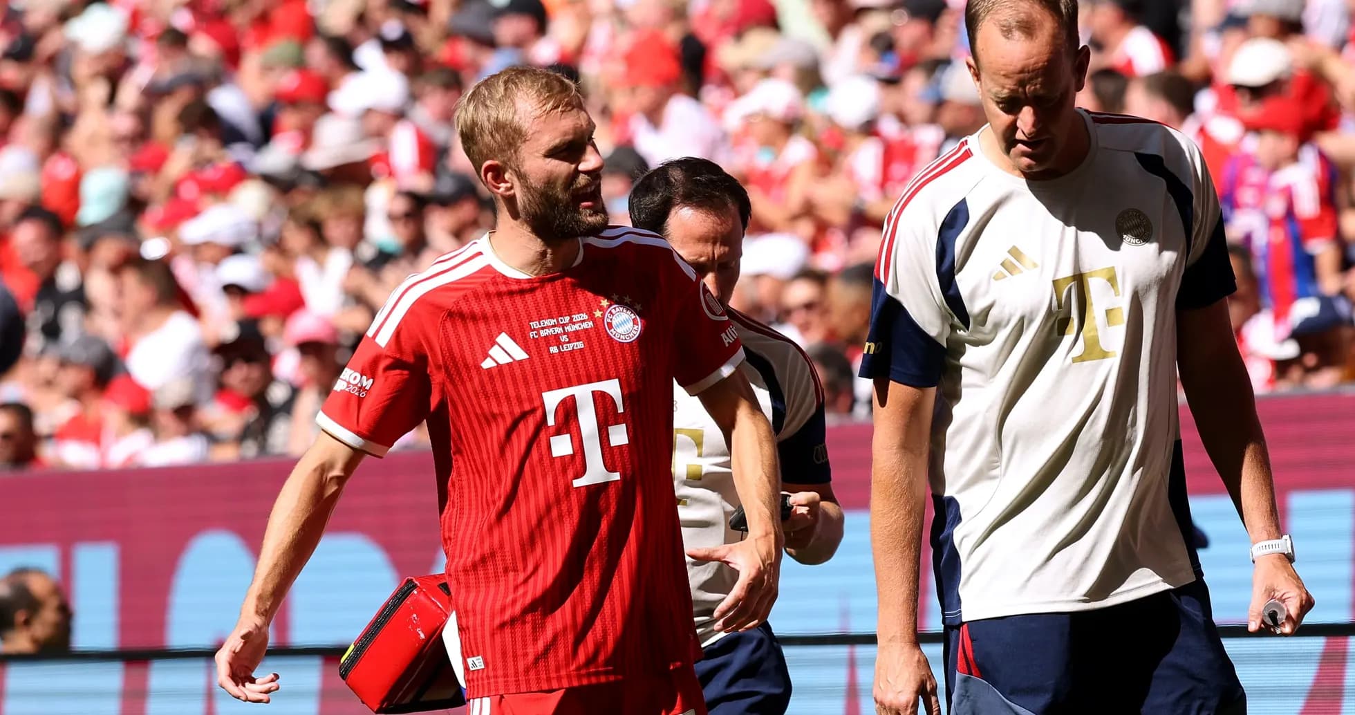 Jugador de Bayern Munich saliendo del campo con médico Jugador de Bayern Munich saliendo del campo con médico