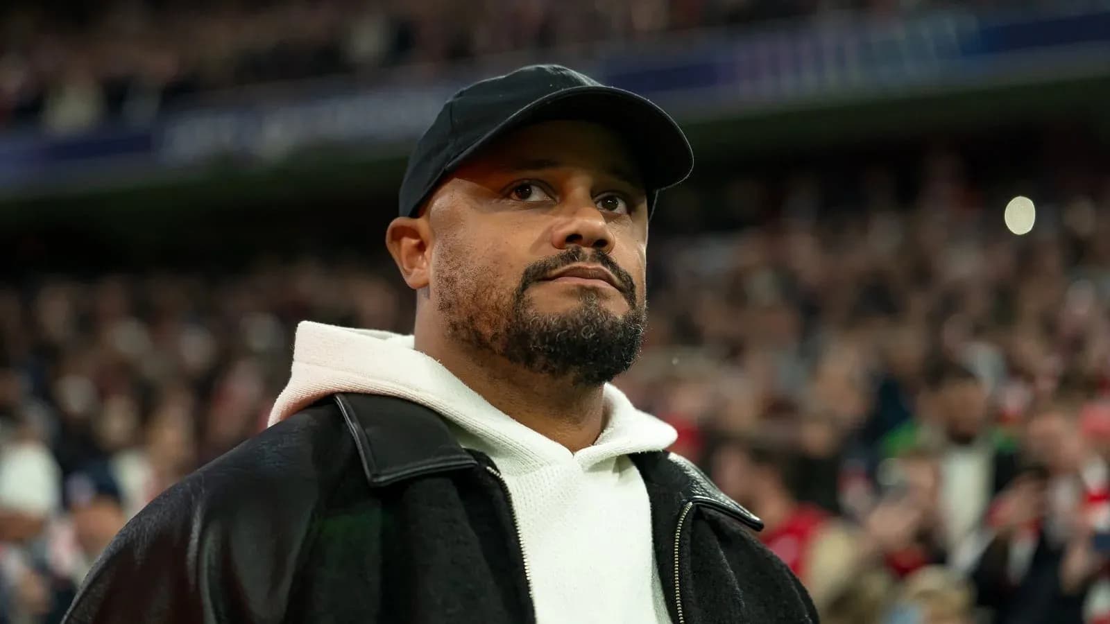 Hombre con chaqueta negra en un estadio lleno Hombre con chaqueta negra en un estadio lleno