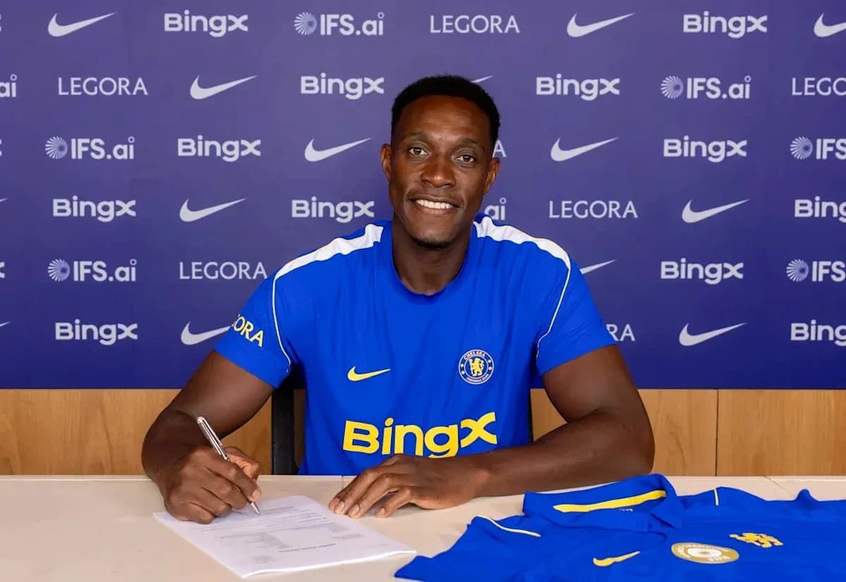 Jugador firmando contrato con Chelsea en mesa Jugador firmando contrato con Chelsea en mesa