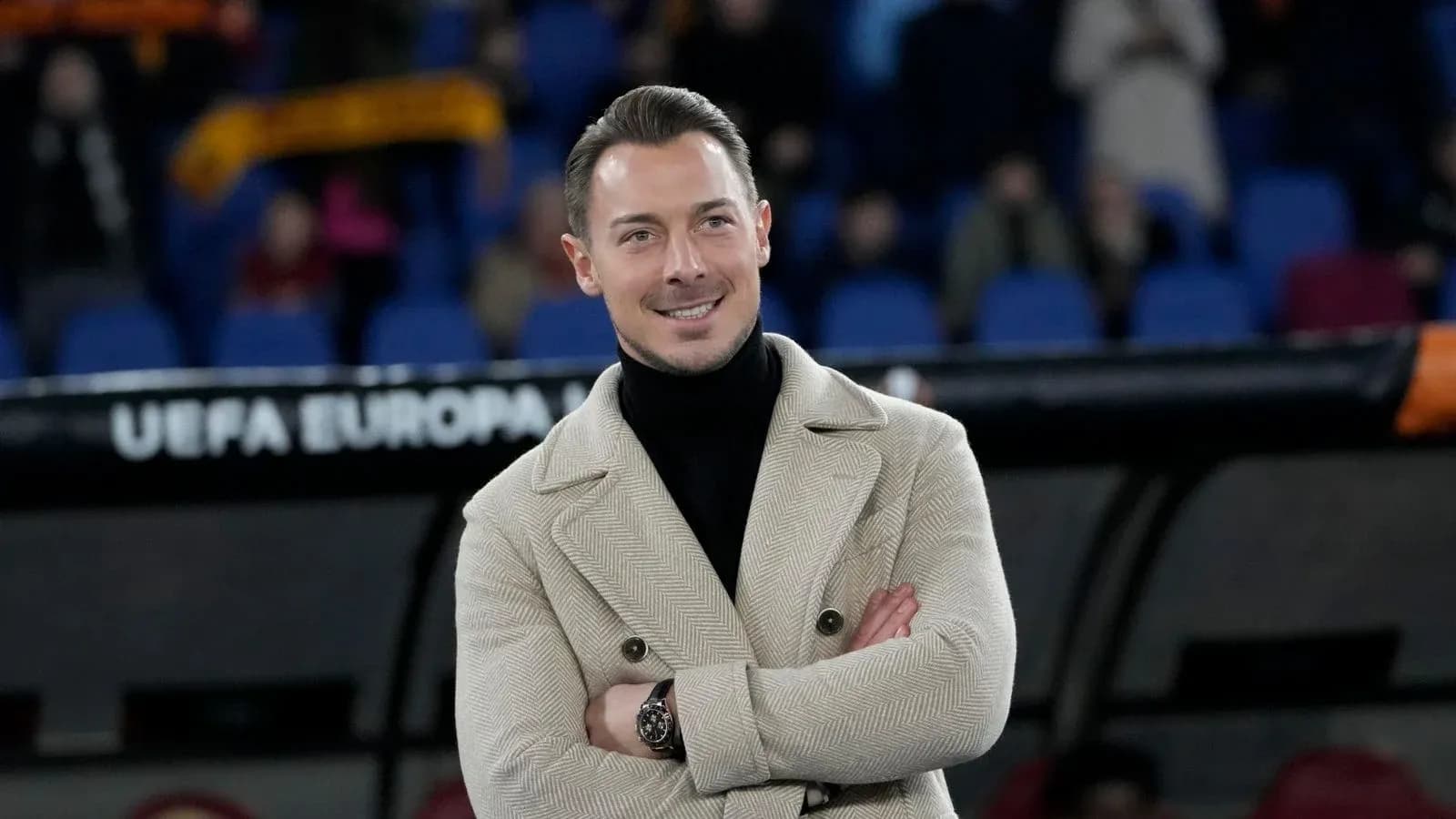 Hombre sonriendo con abrigo en el estadio Hombre sonriendo con abrigo en el estadio