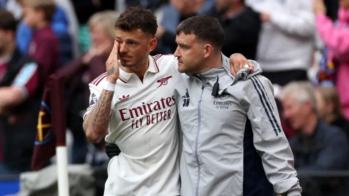 Jugador de Arsenal siendo ayudado por un miembro del equipo Jugador de Arsenal siendo ayudado por un miembro del equipo