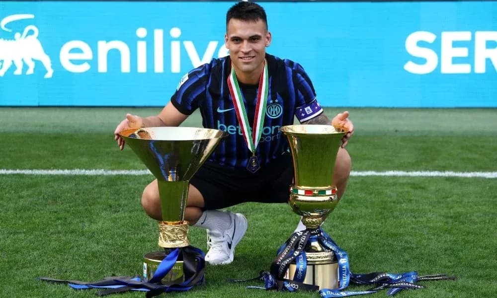 Jugador con dos trofeos en campo de fútbol Jugador con dos trofeos en campo de fútbol