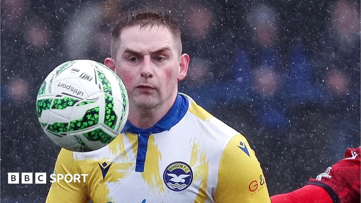Jugador de Bangor FC controlando el balón en la lluvia Jugador de Bangor FC controlando el balón en la lluvia